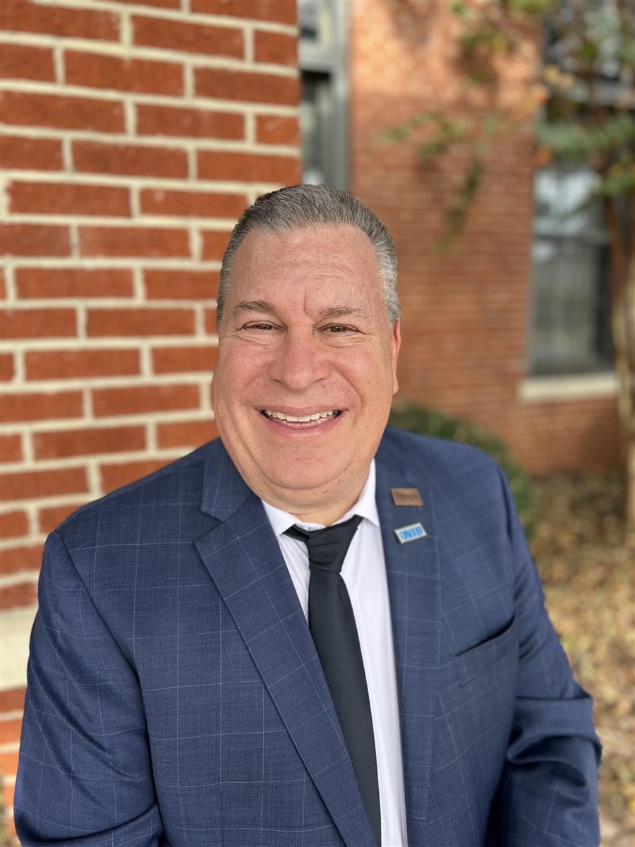  Jeff Papalia smiles to camera while wearing a suit.